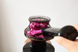 边榨汁边用推压棒不停的推放紫甘蓝；