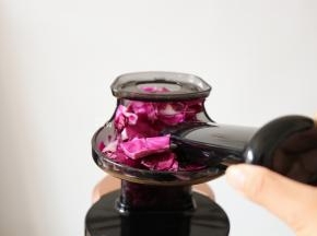 边榨汁边用推压棒不停的推放紫甘蓝；