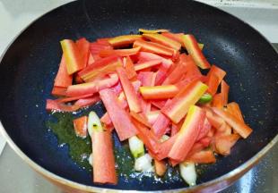 锅里留底油，放入葱蒜爆香，然后倒入胡萝卜片翻炒三分钟。