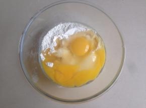将两个鸡蛋磕入面粉中，加入花生油