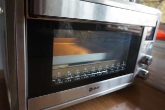 预热东菱K40C烤箱到上火120度，下火150度，烤箱预热的时间正好是醒面的时间，在醒面后的面饼坯上铺一张油纸，再放上另一个烤盘。放入烤箱最下面一层，烘烤12分钟，为了上色更均匀，再将面饼翻面，移至中下层，继续烘烤7分钟