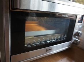 预热东菱K40C烤箱到上火120度，下火150度，烤箱预热的时间正好是醒面的时间，在醒面后的面饼坯上铺一张油纸，再放上另一个烤盘。放入烤箱最下面一层，烘烤12分钟，为了上色更均匀，再将面饼翻面，移至中下层，继续烘烤7分钟