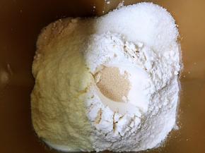 将面包食材投进面包搅拌桶内，搅拌一个三十分钟的程序，加入黄油再搅拌二十分钟