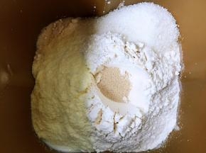 将面包食材投进面包搅拌桶内，搅拌一个三十分钟的程序，加入黄油再搅拌二十分钟