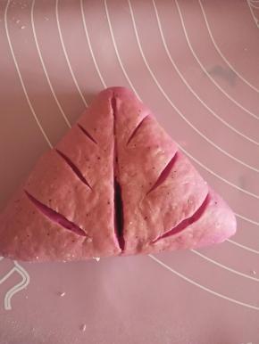 醒发好的面团，擀开，包入红豆沙包成三角形或者圆形，什么形状都可以，拿刀片割口，自己喜欢随意