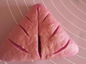 醒发好的面团，擀开，包入红豆沙包成三角形或者圆形，什么形状都可以，拿刀片割口，自己喜欢随意