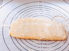 硅胶垫撒面粉，将面糊反复折叠，用手掌轻轻按压成约一厘米厚的长条饼状