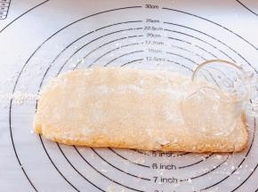 硅胶垫撒面粉，将面糊反复折叠，用手掌轻轻按压成约一厘米厚的长条饼状