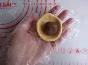 分成12个，每个35克的小剂子，馅料分成每个15克，搓圆备用。未操作的糯米粉团先盖上保鲜膜，防止风干，将小剂子压扁后放入馅料