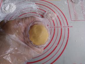 表面扑点熟糕粉，50克月饼模也在熟糕粉里按压一下，多余的粉抖去，再将糯米团放入