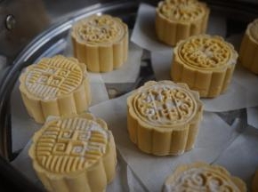 将月饼放在油纸上，再放入蒸锅里