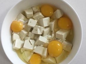 把鸡蛋磕入碗中。