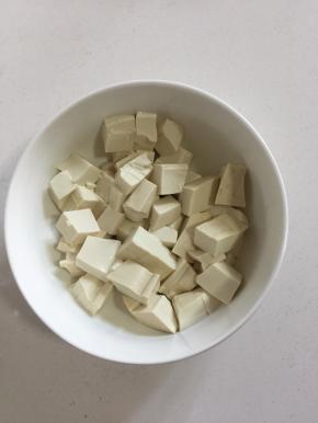 嫩豆腐切成块儿放入碗中。