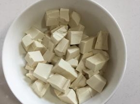 嫩豆腐切成块儿放入碗中。