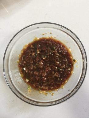 肉馅中放入葱花，盐1勺，鸡精1勺，十三香1小勺，海鲜酱油2勺，蚝油1勺，蒸鱼豉油2勺，豆油1勺搅拌均匀。