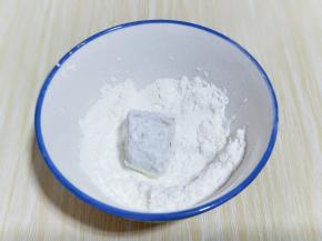 首先将一段香蕉放入淀粉碗中，裹满淀粉。