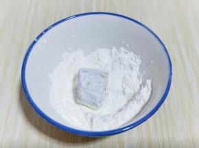 首先将一段香蕉放入淀粉碗中，裹满淀粉。