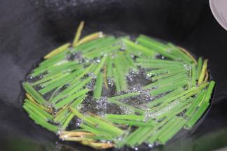 炸出香味时，加入葱叶段，中小火油炸。