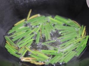 炸出香味时，加入葱叶段，中小火油炸。