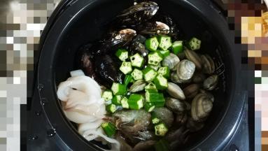 电饭煲显示到还剩15分钟时放入海鲜类、蔬果类洒上少许蒜盐，盖上盖子至工作完成，饭好后再焗5分钟