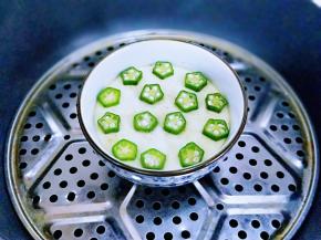 6分钟后把焯水并切好的秋葵放在蛋羹上面，盖上盘子再整2分钟，关火焖2分钟。