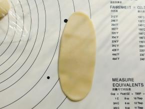 把面团擀成牛舌形，第一次不要擀的太长。