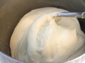 将除黄油和盐外的面团材料加入厨师机搅拌桶，开启低档聚成团后转中速档揉面。