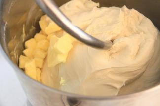 面团揉至较光滑状态后加入软化的黄油，低档揉至黄油吸收后转中速揉面。