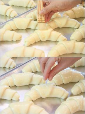 在发酵好的面团表面刷上蛋液，中间位置放少量海盐粒。