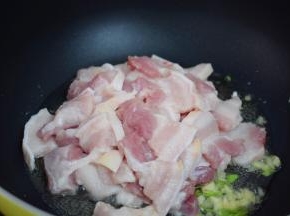 再放入五花肉，翻炒至变色