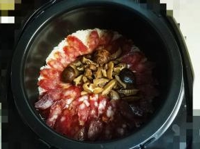 等到饭煲出烟（蒸汽）放入腊肠和花菇至煮饭程序结束