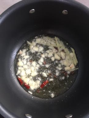 锅烧热倒入适量的油，烧至七成热，放入蒜瓣，生姜，花椒和干辣椒爆香。