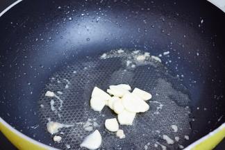 原锅倒入少许食用油烧热，放入蒜片爆香