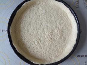 松弛好的面团擀成8寸披萨盘的圆形放入披萨盘中整理出形状，用叉子在饼坯上戳孔，一定要戳透不然在烤制的过程中容易鼓包