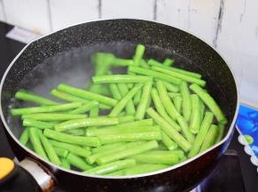 锅中烧开水，倒入少许食用油和盐，再放入豇豆焯水