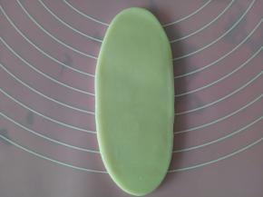 取一个包好的，从中间向上向下擀开，擀成大约10厘米长的牛舌状