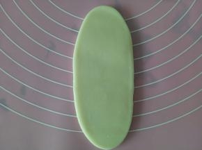 取一个包好的，从中间向上向下擀开，擀成大约10厘米长的牛舌状