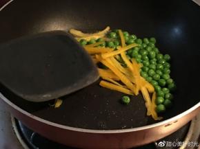 平底锅倒入橄榄油，放入青豆和彩椒丝，放入适量盐翻炒
