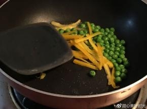 平底锅倒入橄榄油，放入青豆和彩椒丝，放入适量盐翻炒