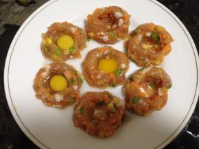 用手在丸子中间按一个坑，打入一个鹌鹑蛋