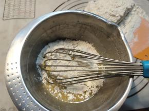 将三分之一的月饼粉加入准备好的糖浆液体内，搅拌至看不到粉末即可。