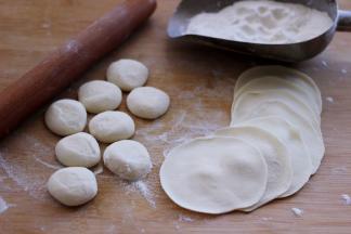 摁扁后用擀面杖擀成圆形薄面皮。