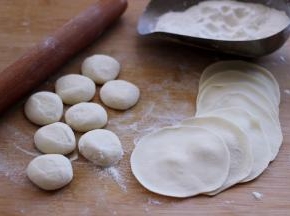 摁扁后用擀面杖擀成圆形薄面皮。