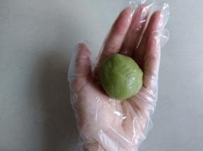 皮往上推，皮与馅紧密粘合，用右手虎口收口，搓圆