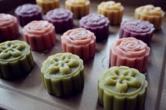 在烤盘上压出月饼花形，全部做好后，在表面刷薄薄一层水，不要刷多了