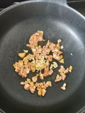 锅烧热后倒入适量油，下鸡丁和蒜蓉，翻炒片刻。