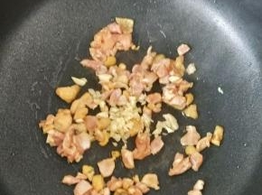 锅烧热后倒入适量油，下鸡丁和蒜蓉，翻炒片刻。