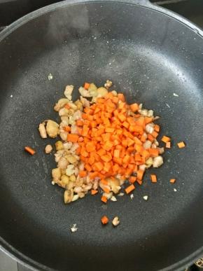 然后放入胡萝卜丁，翻炒均匀。