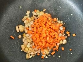 然后放入胡萝卜丁，翻炒均匀。