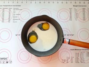 3、鸡蛋、白糖、牛奶和淡奶油倒入小锅中。